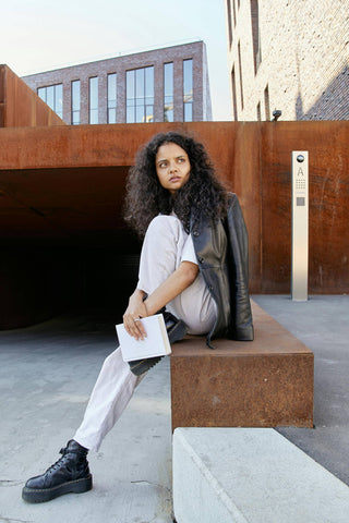 Woman posing with white jeans, combat boots and a leather jacket