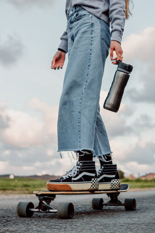 Photo of culotte jeans and black vans on a skateboard