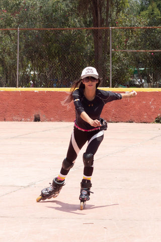 Woman rollerskating wearing leggings and protective pads