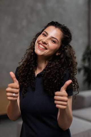 Femme souriante posant avec un polo bleu marine