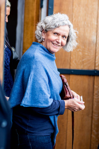 Shot of a woman smiling and wearing jeans and a poncho