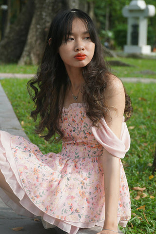 Korean girl posing sitting with a pastel dress with flower motifs