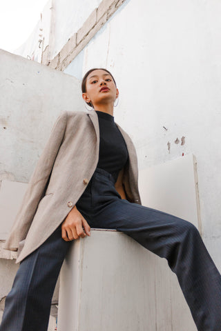 Woman posing in a dressy pants and a black turtleneck