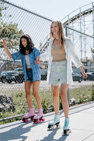 Zwei Mädchen beim Rollschuhlaufen in Jeansshorts