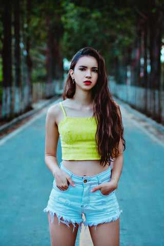 Young woman posing with denim shorts and a crop top
