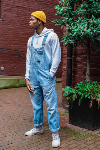 Man posing with a hoodie and denim rompers
