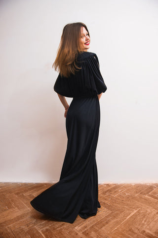 A woman posing in a black maxi dress