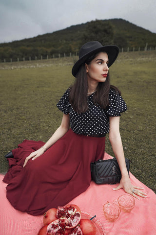 Woman having a picnic wearing a long skirt and polka dot blouse