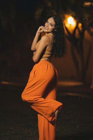 Woman posing with orange wide-leg pants