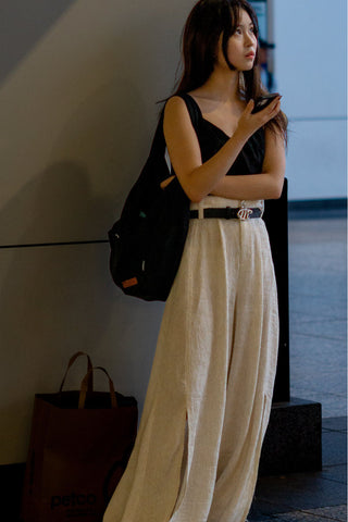 Photo of a woman wearing white palazzo pants over a black top