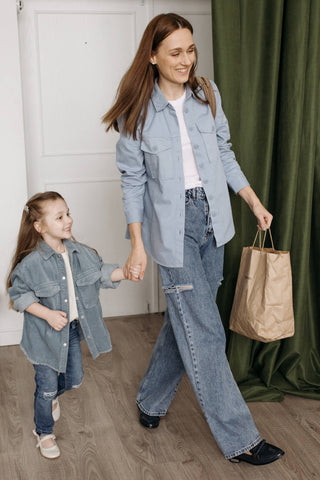 Mother and daughter walking together dressed in matching outfits of wide-leg jeans
