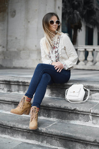 Girl sitting on stairs wearing stringed ankle boots