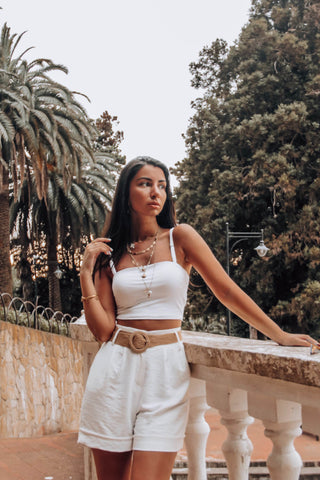 Young woman posing with a crop top and tailored dress shorts