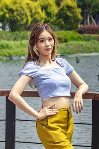Girl posing with a short-sleeved crop top and yellow pants
