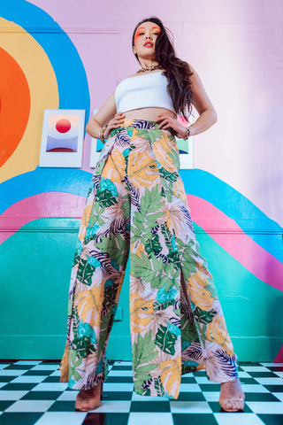 Woman posing with floral wide-leg pants and a white crop top