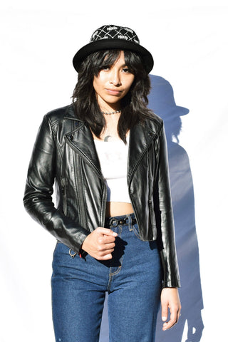 Woman posing in a black leather jacket and jeans