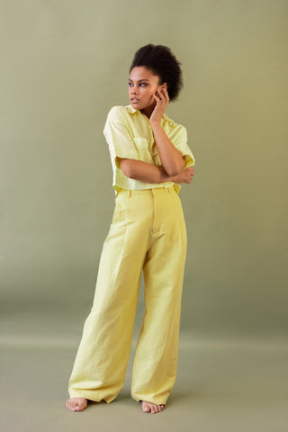 Woman posing in yellow palazzo pants and shirt