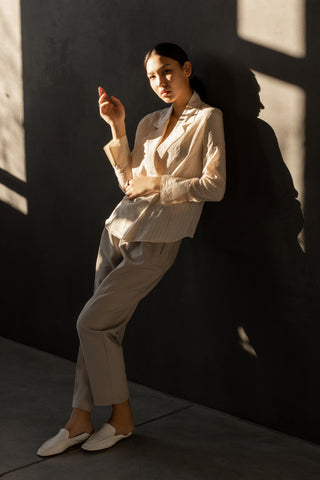 woman posing laying on a wall with dressy pants and a blazer
