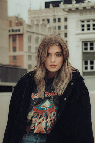 Close photo of a girl wearing a band t-shirt and black jacket