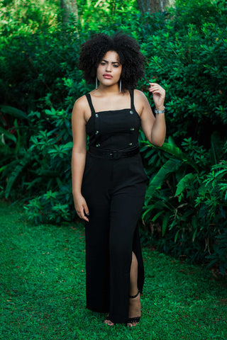 Black woman posing with a black structured jumpsuit