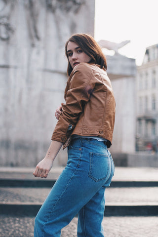 Girl posing for a photo wearing leather jacket and jeans
