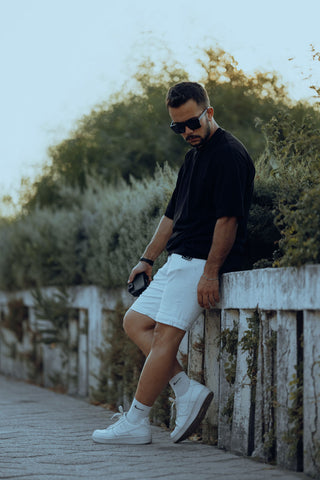 Man posing with white tailored shorts and black basic tee