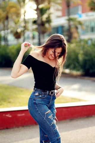Girl posing in ripped jeans and an off-shoulder top
