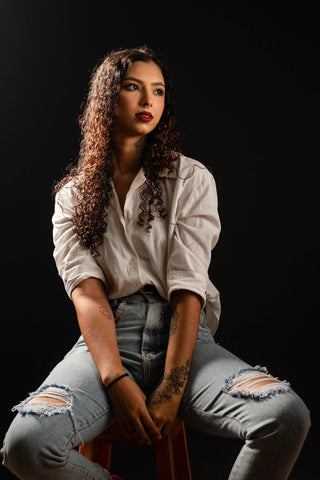 Girl posing with a white button-up and ripped jeans