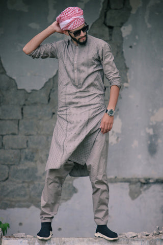 Man posing in grey kurta outfit and slip-on sneakers