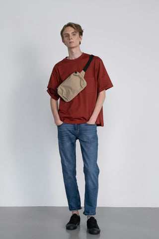 Young man posing with a red tee over straight-leg jeans