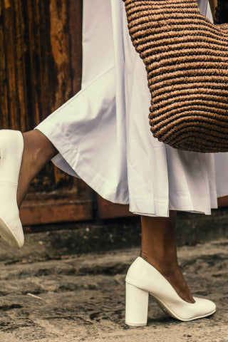 A partial photo of woman walking in white shoes