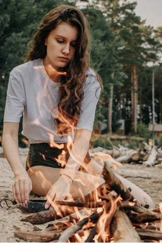Girl setting a fire on the beach