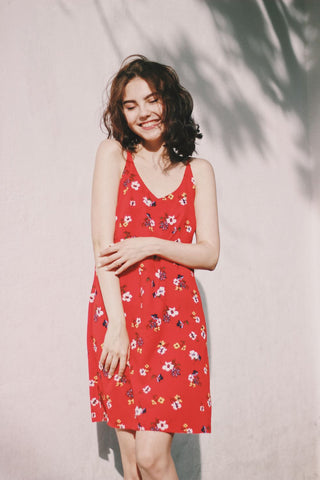 Frau in einem leuchtend roten Kleid mit Blumendruck