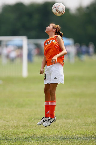 girl jumping soccer boots