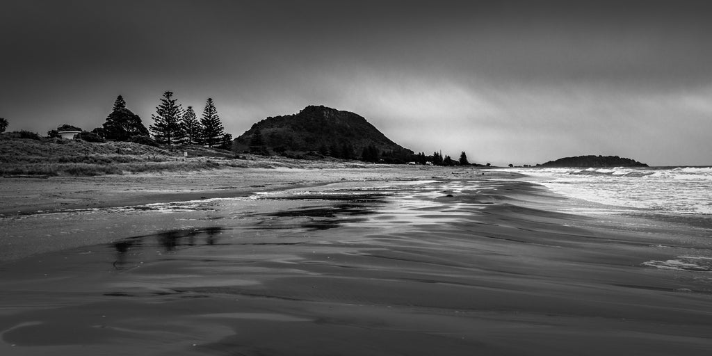 black and white photograph of Mount Maunganui in the distance from Papamoa Beach