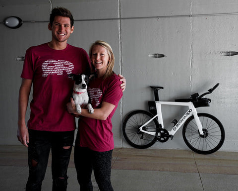 Jeanni Seymour standing behind a white QR bike with her dog and boyfriend Justin Metzler