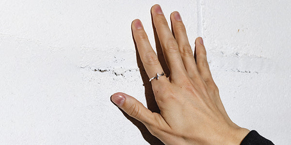 hand on wall with silver fuck ring