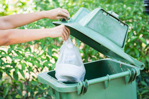 Throwing trash away in outdoor bin