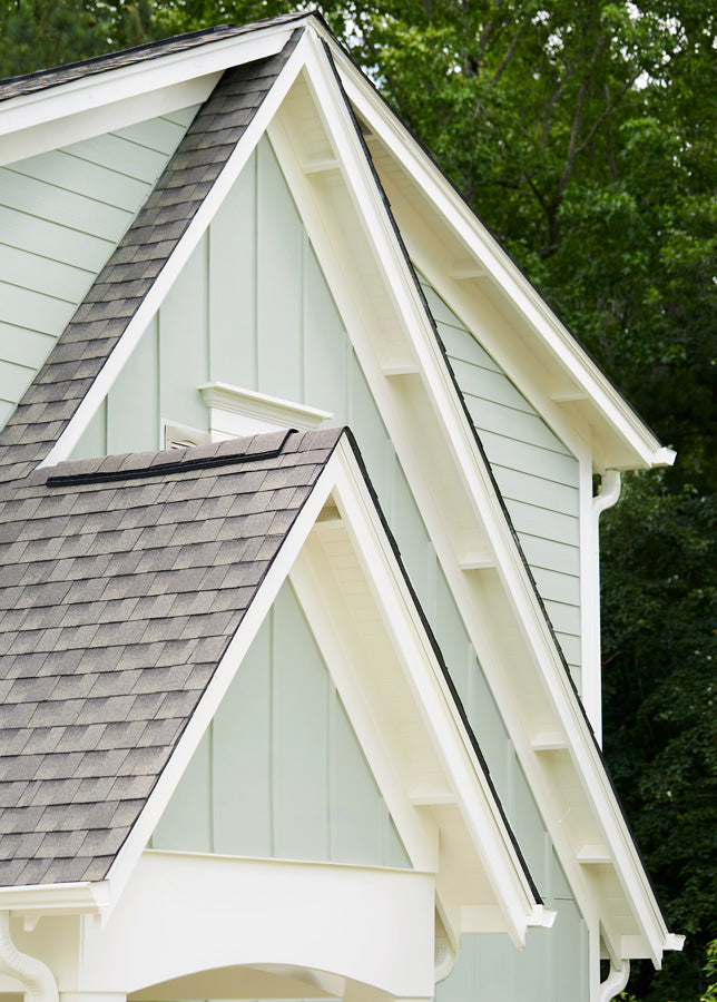 The eaves and trim of this cottage exterior were painted with Timeless, a creamy neutral. The siding is painted with a gray exterior paint named Grayish. 