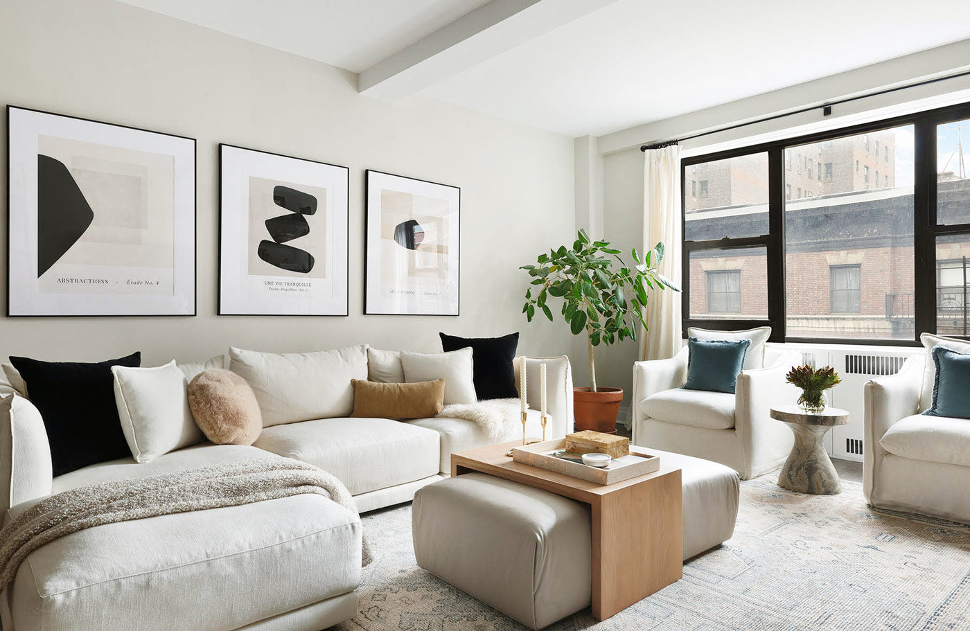 This chic modern living room appears spacious with its neutral color palette and light beige painted walls by Alex Nino.