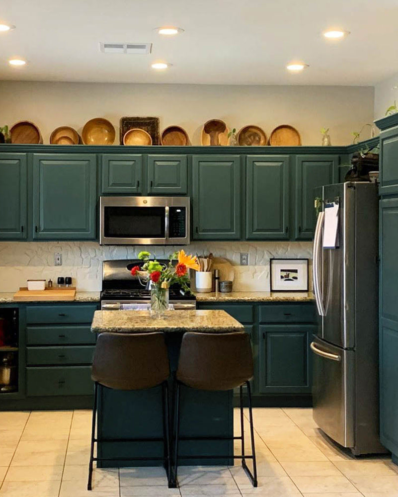 These dark green kitchen cabinets were painted using Current Mood by Clare. Learn how to paint your own cabinets and get the look!