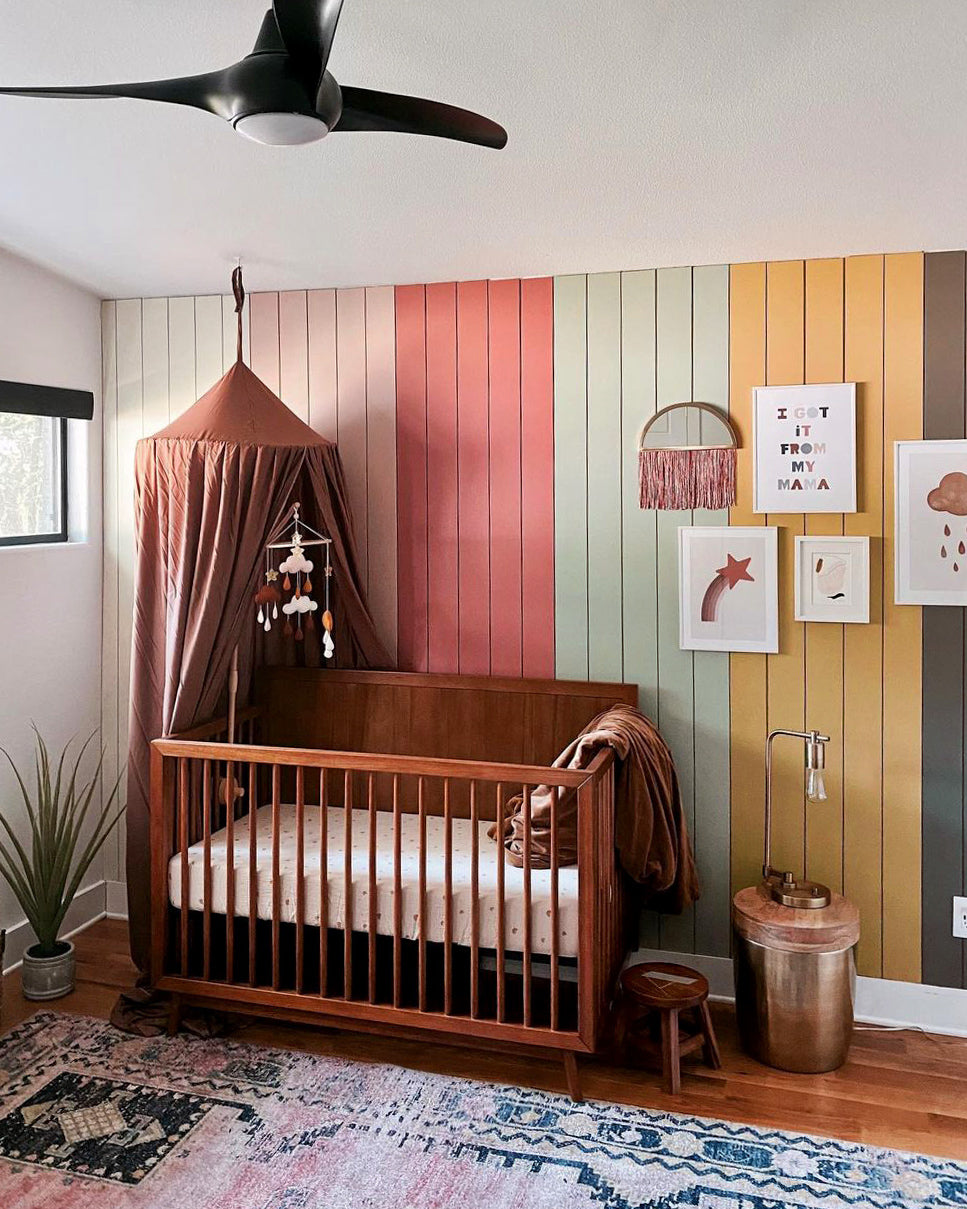 Creative paint ideas to inspire your next paint project. This nursery features a multicolored wall painted with Clare. 