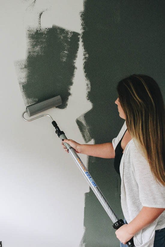 Elizabeth Rishel of the blog Within the Grove painting a green accent wall in her kids room. Bedroom accent wall color is Current Mood by Clare.