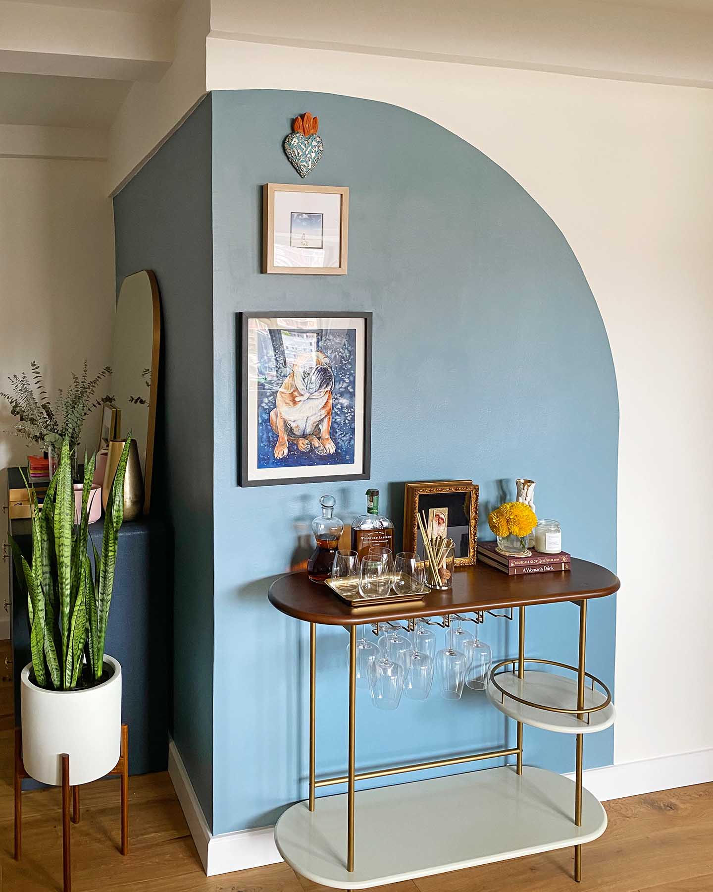 A paint quart is all you need to for an accent wall project like this one featuring a trendy arch painted in Clare’s Good Jeans blue paint. 