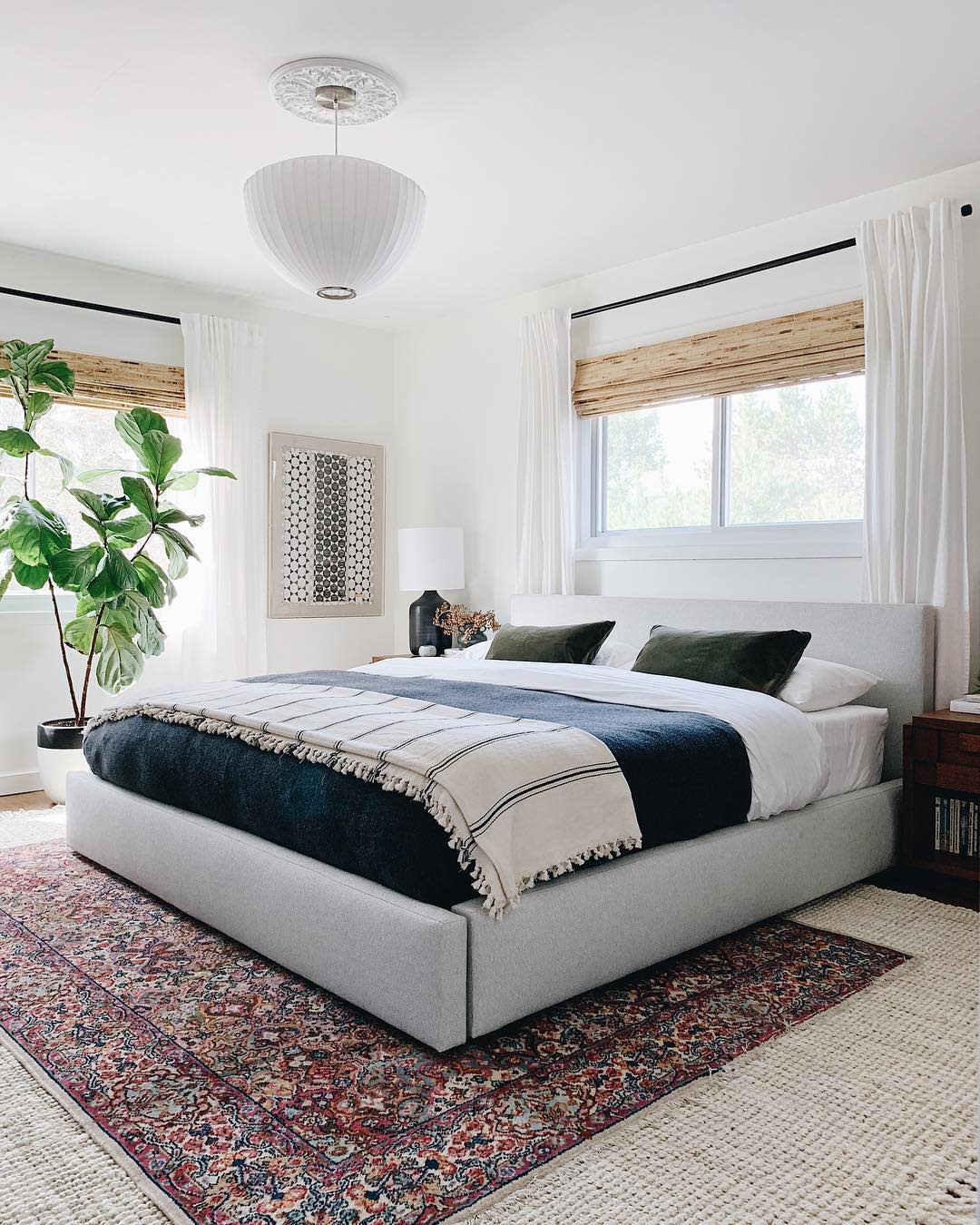 White Walls painted in Whipped, a warm white paint color by Clare, make this bedroom feel warm and inviting.  Lots of texture and plants add a cozy vibe. 