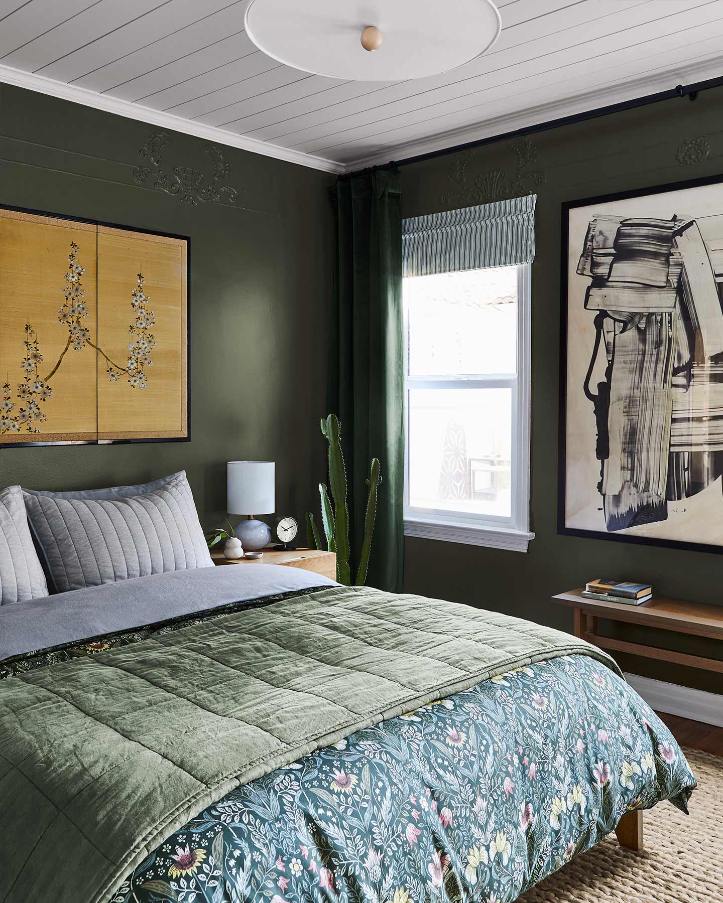 Small-space-friendly furniture keeps this petite dark green bedroom from feeling cramped.