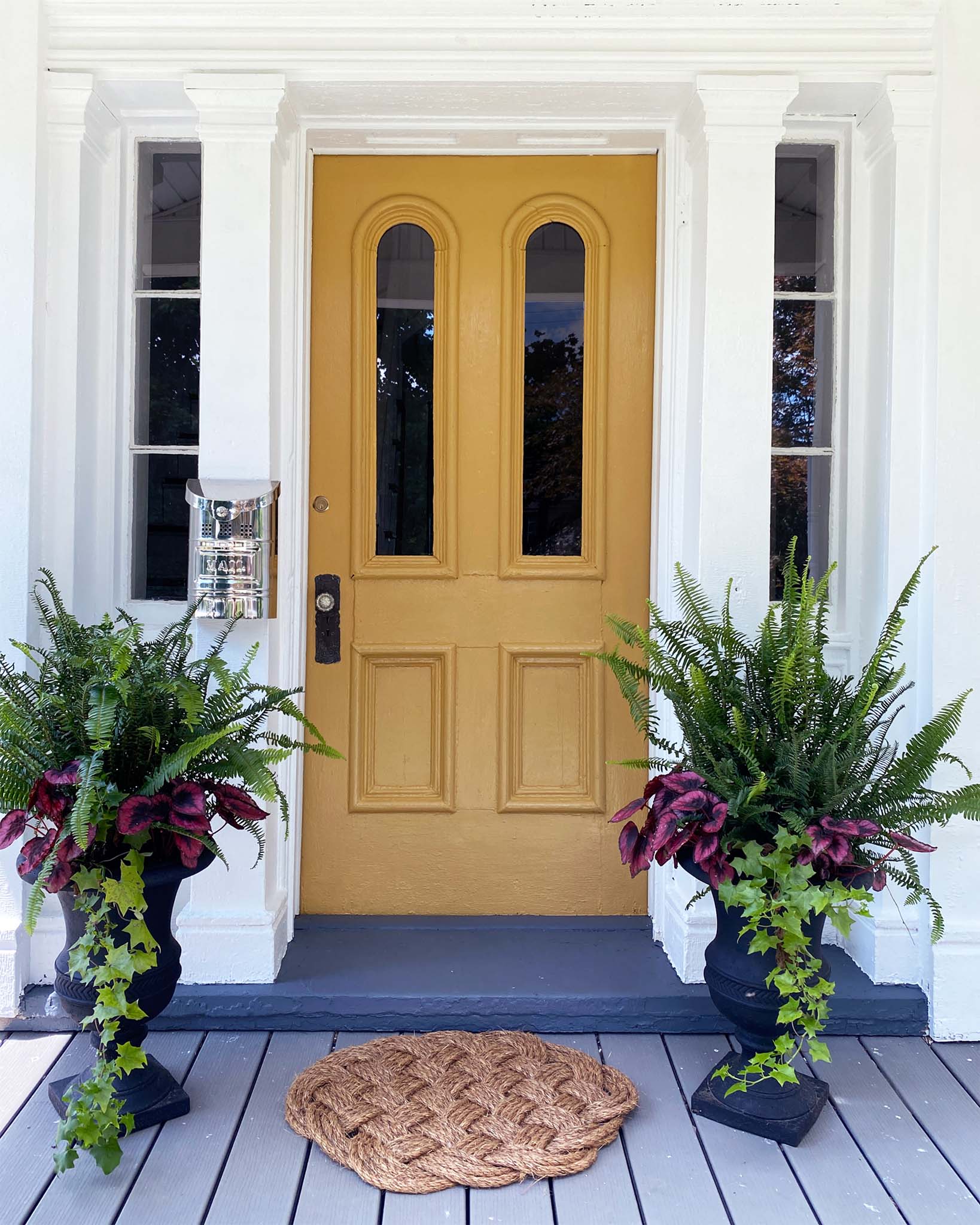 How to Paint a Front Door: Before and After. Reinstalling the door back on its hinges. A yellow painted front door and a charming front porch.  