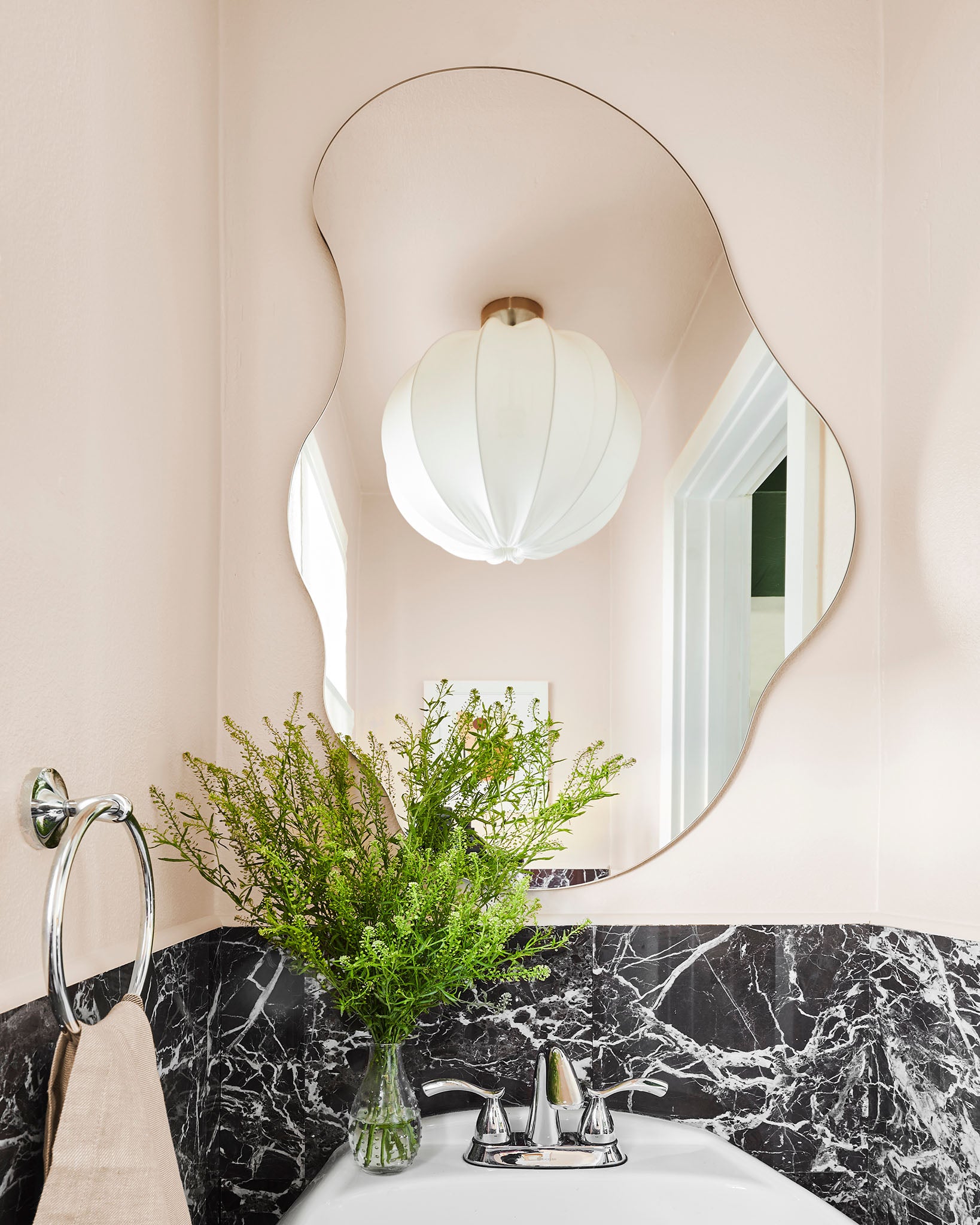 An asymmetrical mirror and oversized light fixture are great ideas for a powder room.