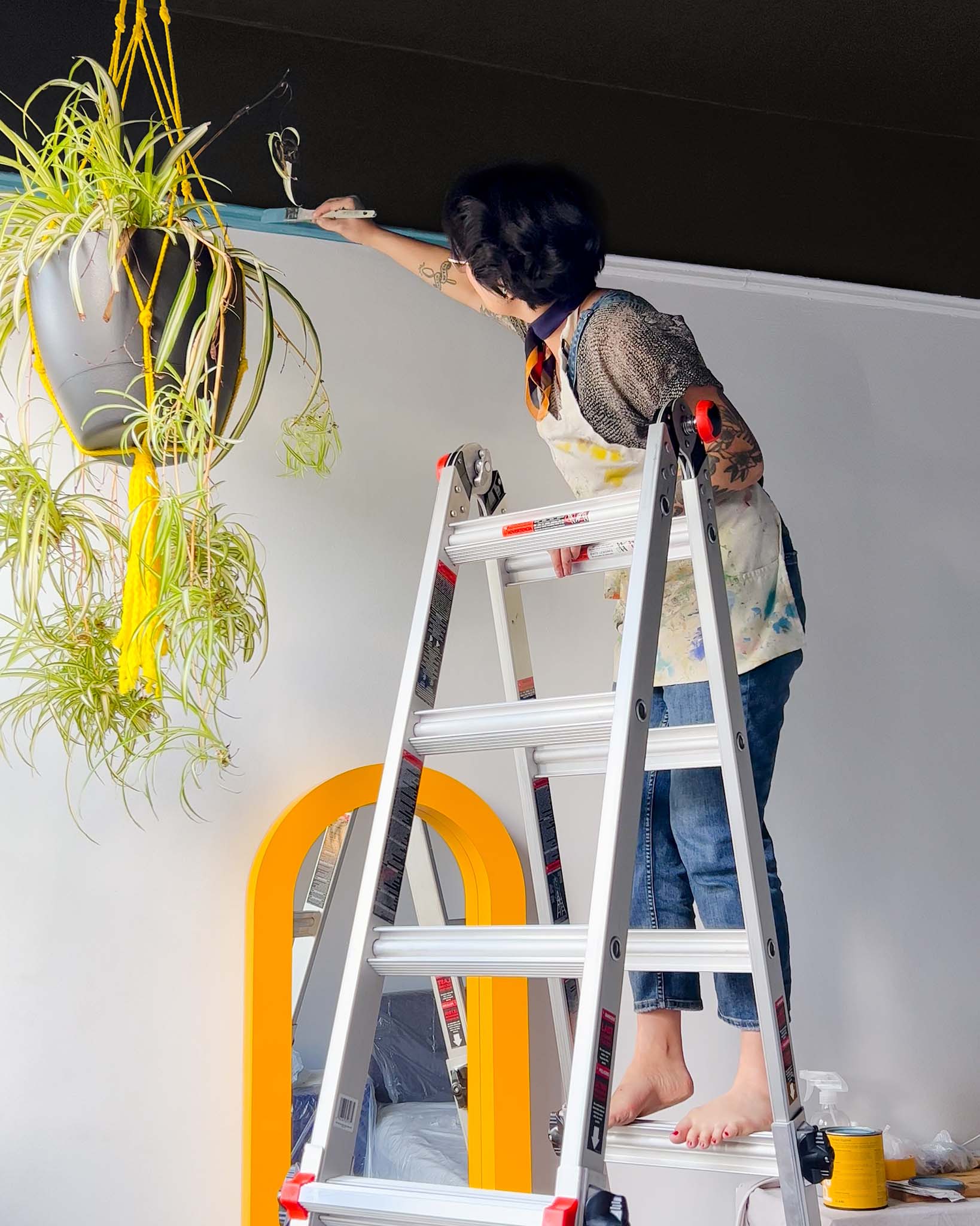 Clare Collective ambassador Lauren Hom painting the ceiling black with Blackish and picture rail with Matcha Latte, Hyperlink, Fire Sign, Rose Season, Golden Hour and Blue Ivy, all paint color by Clare. Check out this personality-filled NYC bedroom on the Clare blog.