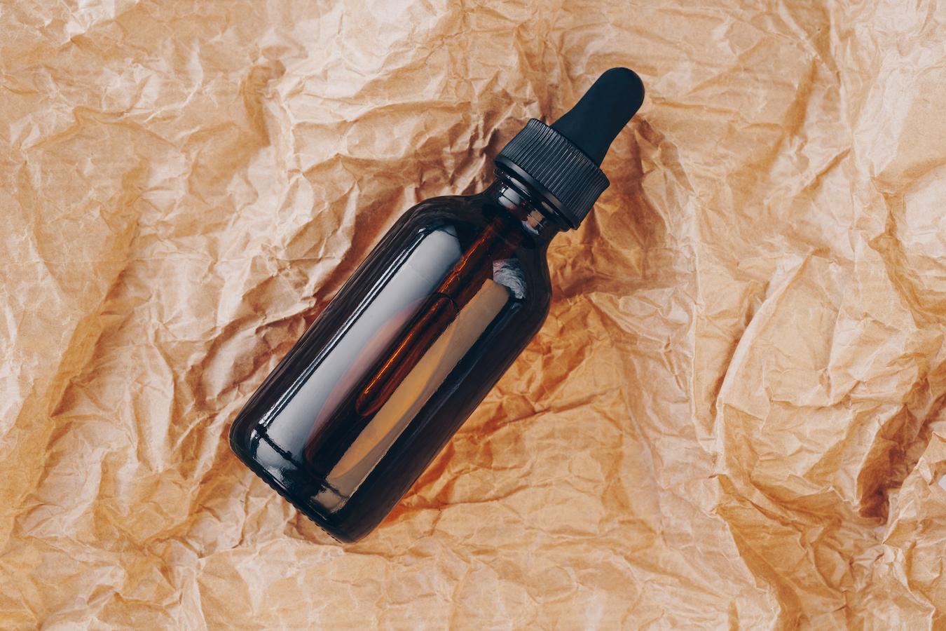 a bottle of tincture on a piece of paper essential oil ethyl alcohol plant compounds herbal tincture plant material essential oils essential oils herbal tinctures cannabis tincture essential oils